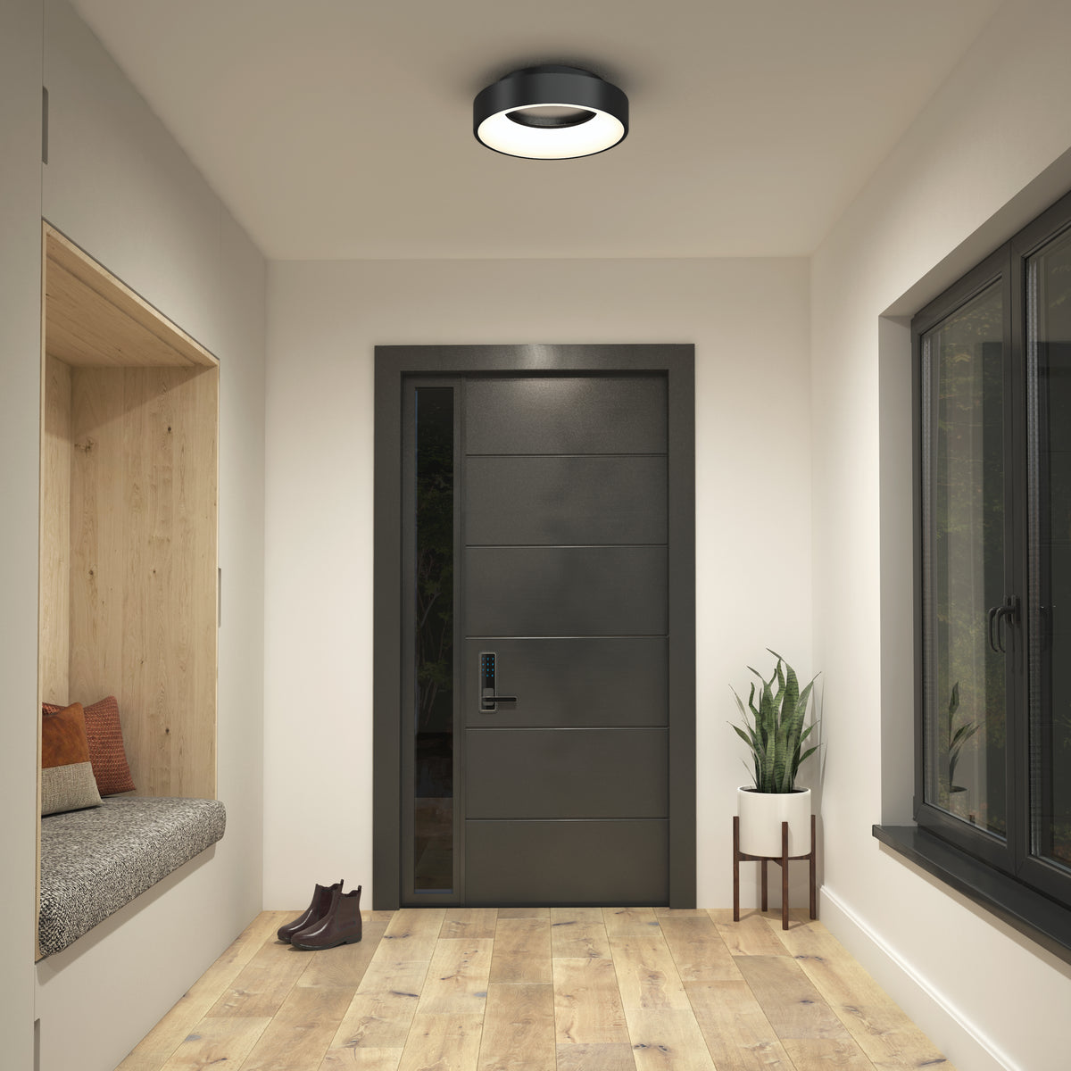 A modern entryway with a black front door, a built-in bench with pillows on the left, a small plant on a stand to the right, and a pair of brown boots on a light wood floor. A round ceiling light is overhead.