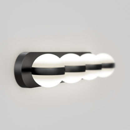 The Artika Baldric LED modern bathroom vanity light features three spherical white bulbs in a sleek black metal frame, wall-mounted and set against a plain gray background.