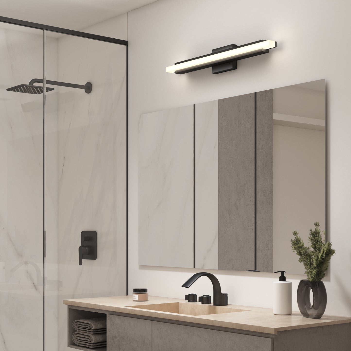 Modern bathroom with a large mirror, black faucet, and the Artika Ophelia modern LED bathroom vanity light 5 CCT above. On the left, a glass shower features a rainfall showerhead. Minimalist decor includes a plant and toiletries on the beige countertop.