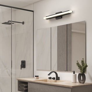 Modern bathroom with a glass shower, black fixtures, a vanity plant, and the Artika Ophelia LED vanity light above the large mirror.