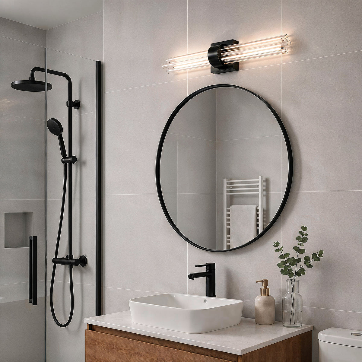 Modern bath with round mirror, black fixtures, wood vanity, and Artika Dorado 27 in. 1-Light LED Wall Vanity 5CCT above the mirror.
