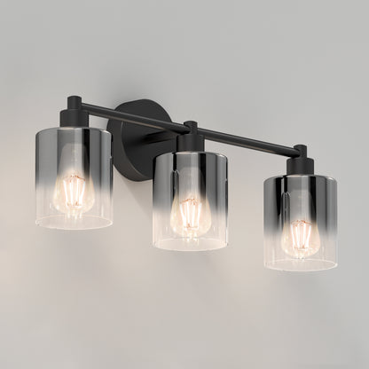 The Artika Haze modern 3-light bathroom vanity light features three exposed bulbs in cylindrical clear glass shades, set on a black metal bar with a round backplate for wall mounting.