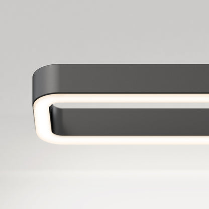 Close-up of the Artika Hinge LED modern bathroom vanity light 3 CCT, a rectangular fixture with rounded edges and a glowing white border, set against a plain light gray background.