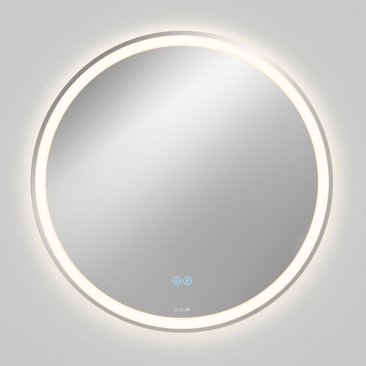 The Artika Ayla 28 in. LED mirror features a round, wall-mounted design with edge illumination, 3 CCT settings, and a built-in defogger. Two touch-sensitive icons are visible on the lower part, casting a soft glow on a plain gray wall.
