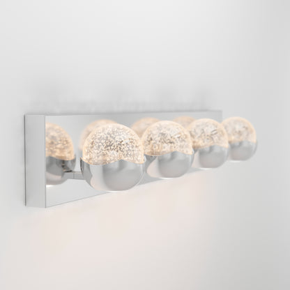 The Artika Oracle LED bathroom vanity light features four chrome half-sphere bulbs with textured translucent domes, all mounted on a rectangular chrome base against a plain white wall.
