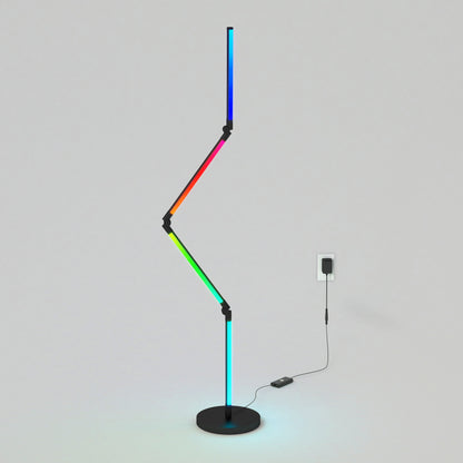 The Artika Fitch smart foldable RGB LED gaming floor lamp features a zigzag, multicolored light on a round black base with a visible black cord, set against a plain light gray background.