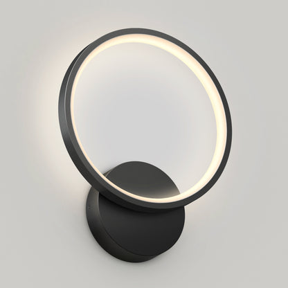 The Artika Solis modern LED indoor-outdoor wall light 5 CCT features a circular LED ring and black base, casting a soft, even glow against a plain light-colored wall.