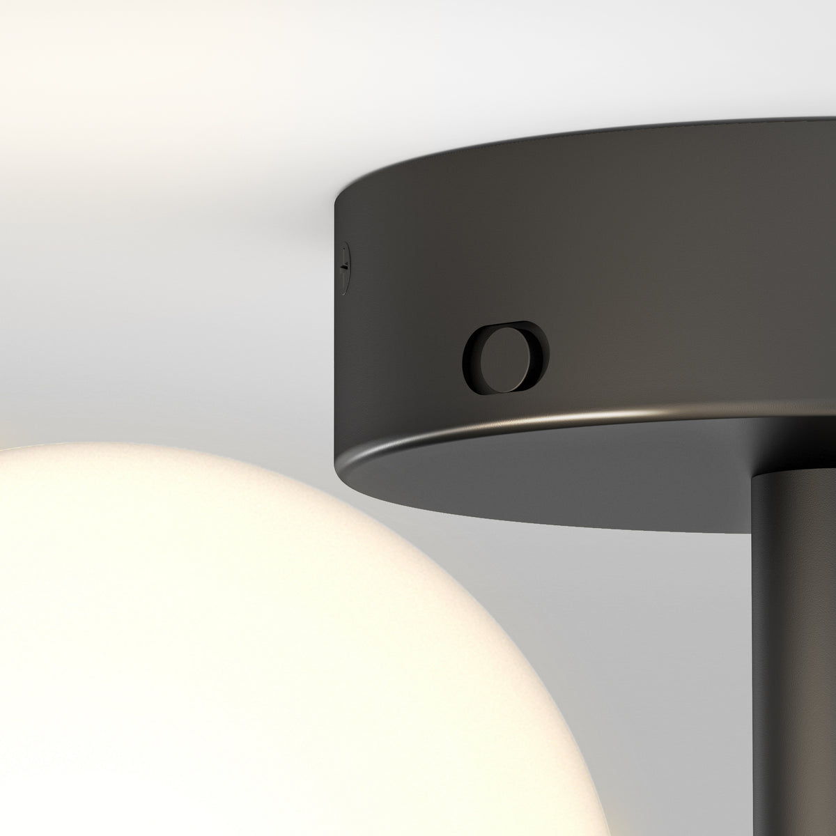 Close-up of a modern ceiling light fixture with a black circular base and a round white glass globe, against a plain white background.