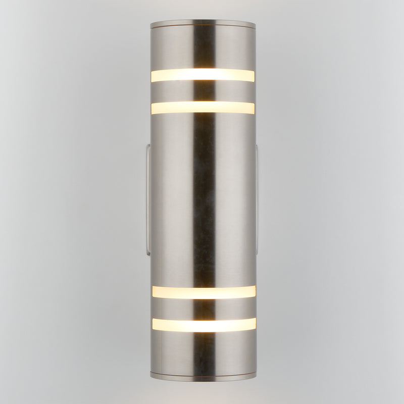 The Artika Voltz indoor-outdoor wall light is a modern cylindrical sconce in brushed metal, featuring horizontal frosted light strips glowing at the top and bottom, mounted vertically against a light gray background.