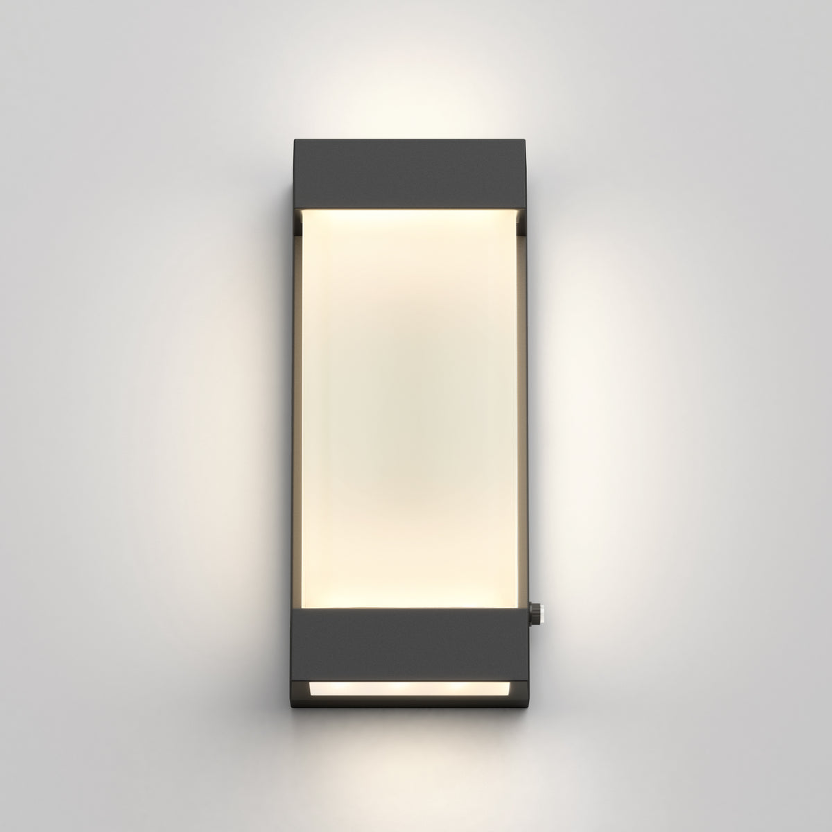 A modern rectangular wall light with a dark frame and a frosted white center, mounted on a light gray wall and emitting a soft glow.