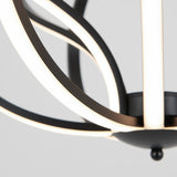Close-up of a modern chandelier featuring curved, black metal arms with integrated LED light strips, shown against a plain, light gray background.
