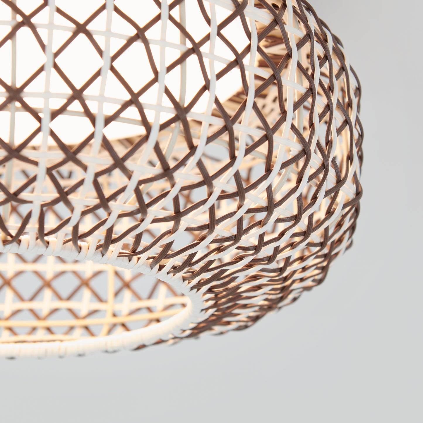 Close-up of the Artika Benson 15 in. LED flush mount light, featuring a woven rattan shade with a crisscross pattern that softly diffuses warm light through its natural brown and white design against a plain background.