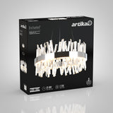 A black box features the Artika Enchanted LED chandelier, showing a modern circular design with crystal-like accents, product details, and lighting specifications on the packaging.