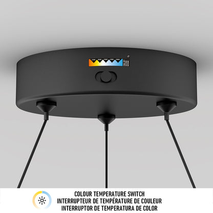 The Artika Bjorn modern LED pendant light 5 CCT is a round black ceiling fixture with three hanging cords and a top color temperature switch, offering customizable warm to cool settings. Below, COLOUR TEMPERATURE SWITCH appears in three languages.