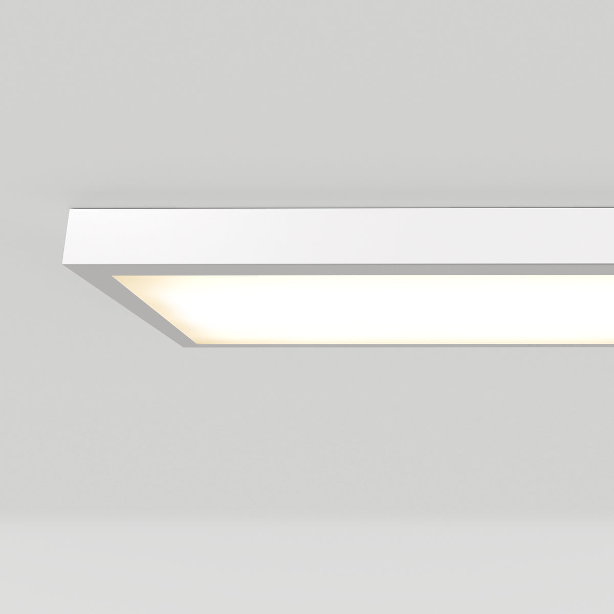 A rectangular, modern ceiling light fixture glows with a soft white light against a plain white ceiling.