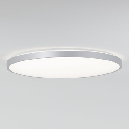 The Artika Jupiter 23 in. LED flush mount light, featuring a round design with a silver rim and smooth white diffuser, is shown illuminated against a plain white ceiling. Remote included.