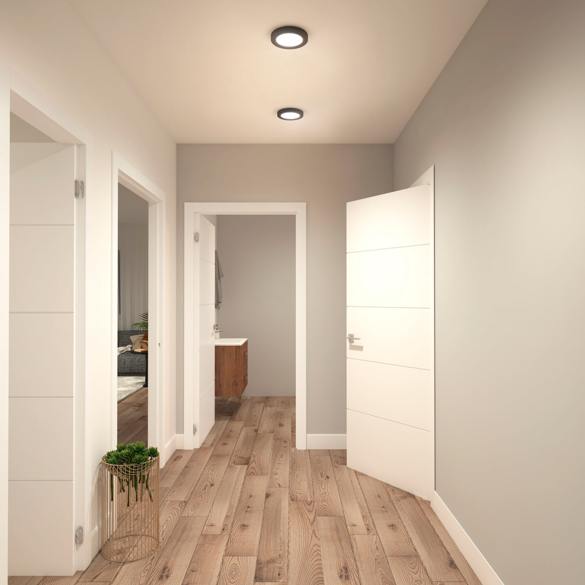 A modern hallway with light gray walls, wooden flooring, two open white doors, and a small plant on a stand. Recessed ceiling lights brighten the space, and a bathroom is visible at the end of the hall.