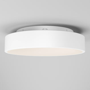 The Artika Aiden LED flush mount is a modern, round white ceiling light with a smooth, minimalist design. Mounted on a light-colored ceiling, it emits a soft, even glow.