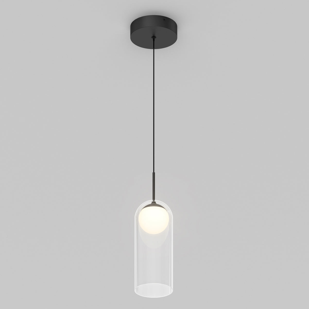 The Artika Mirah LED modern mid-century pendant light 3 CCT features a black ceiling mount and cord with a clear cylindrical glass shade around a glowing bulb, set against a plain light gray background.