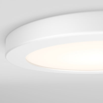 Close-up of Artika’s Europa Disk 7 in. LED modern flush mount light with 3 CCT, featuring a minimalistic, circular design and smooth lines, emitting a soft, warm glow against a white ceiling.