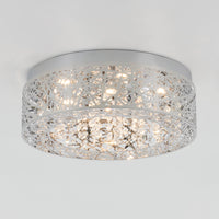 The Artika Crystal Nest LED flush mount is a modern ceiling light featuring a silver geometric lattice and hanging crystal accents, illuminated by multiple small bulbs.