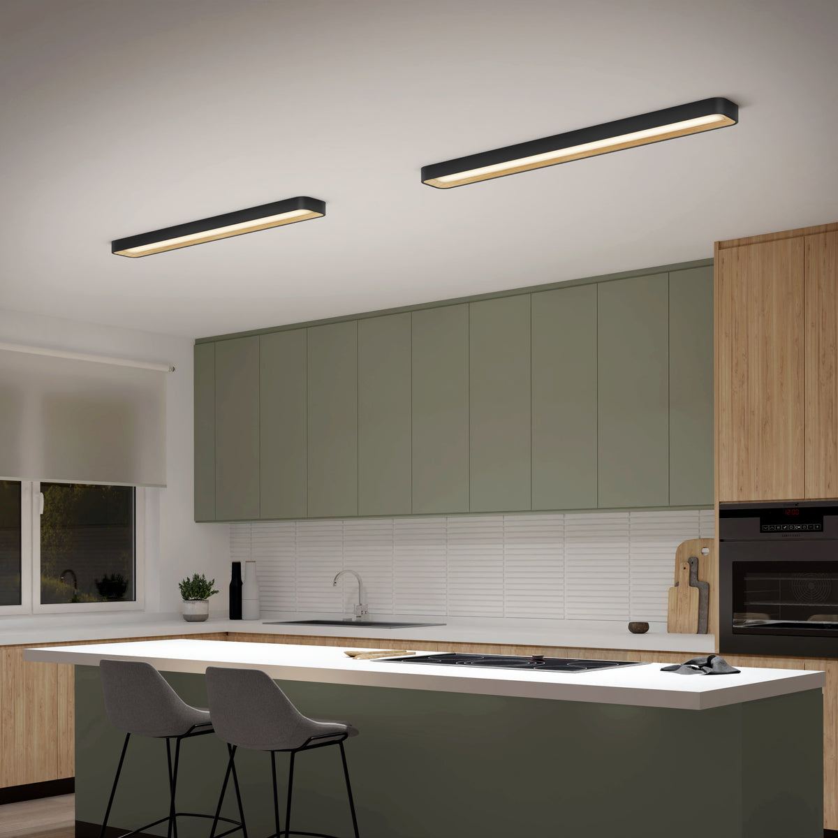 Modern kitchen with light green cabinets, wooden accents, a white countertop island with two gray barstools, built-in oven, sink, and two rectangular ceiling lights. A window with a blind is on the left wall.