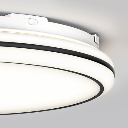Close-up of the Artika Emina 13 in. LED flush mount light 3 CCT, featuring a modern white and black design on a light gray ceiling. The dimmable fixture emits an evenly diffused, soft, bright glow.
