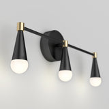 A modern wall sconce with three cone-shaped black and gold light fixtures, each holding a round white bulb, mounted on a circular black base against a light gray wall.