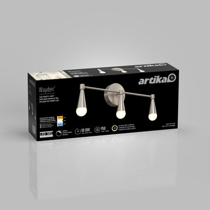 A black rectangular box for the Artika Wayden LED mid-century bathroom vanity light 3 CCT, showing an image of the brushed nickel three-bulb fixture, product details, and branding on a gray background.