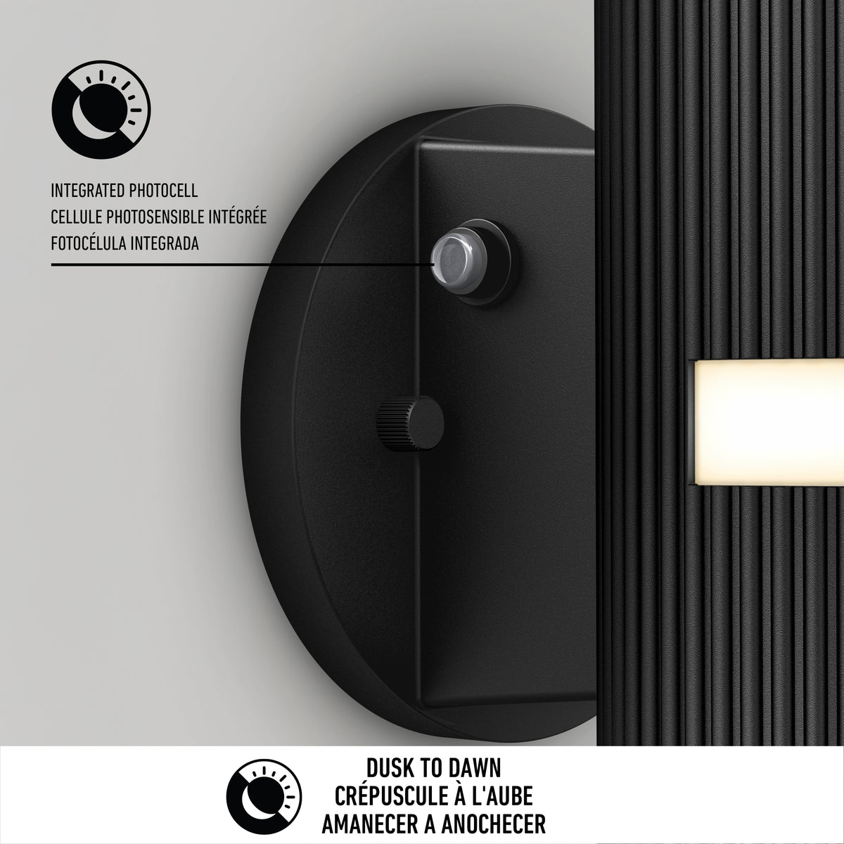 The Artika Groove LED indoor-outdoor wall light features a black finish, integrated photocell sensor, and rectangular panel. Dusk to Dawn is printed in English, French, and Spanish. Diagram highlights the sensor feature.