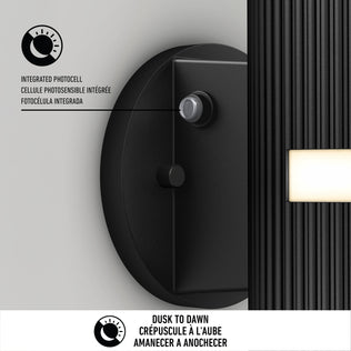 The Artika Groove LED indoor-outdoor wall light features a black finish, integrated photocell sensor, and rectangular panel. Dusk to Dawn is printed in English, French, and Spanish. Diagram highlights the sensor feature.