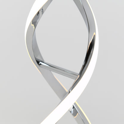 A close-up of the Artika Swirl LED table lamp, featuring a modern twisted design with a sleek chrome finish and integrated LED light, shown against a plain light gray background.