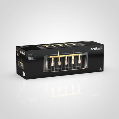 A sleek black rectangular box displays the Artika brand and the Gatsby pendant light, featuring a modern chandelier design with five exposed bulbs and gold accents.