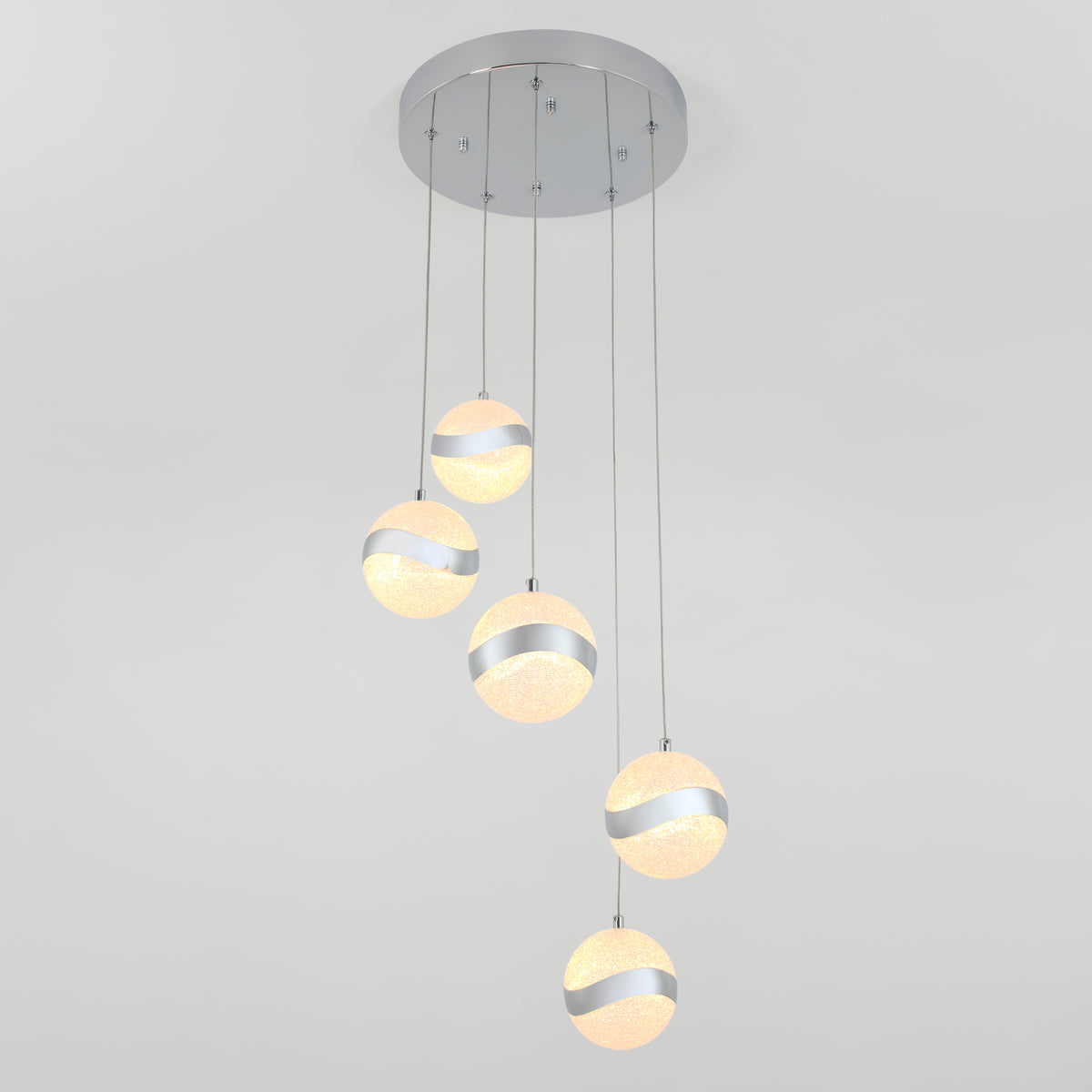 A modern ceiling light fixture with four spherical pendant lights, each featuring a frosted texture and a metallic wave band, suspended at different lengths from a round, silver ceiling mount.