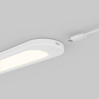 Artika Impulse Under-Cabinet LED Light RGB+CCT with Remote on gray surface, white USB-C cable near the charging port.