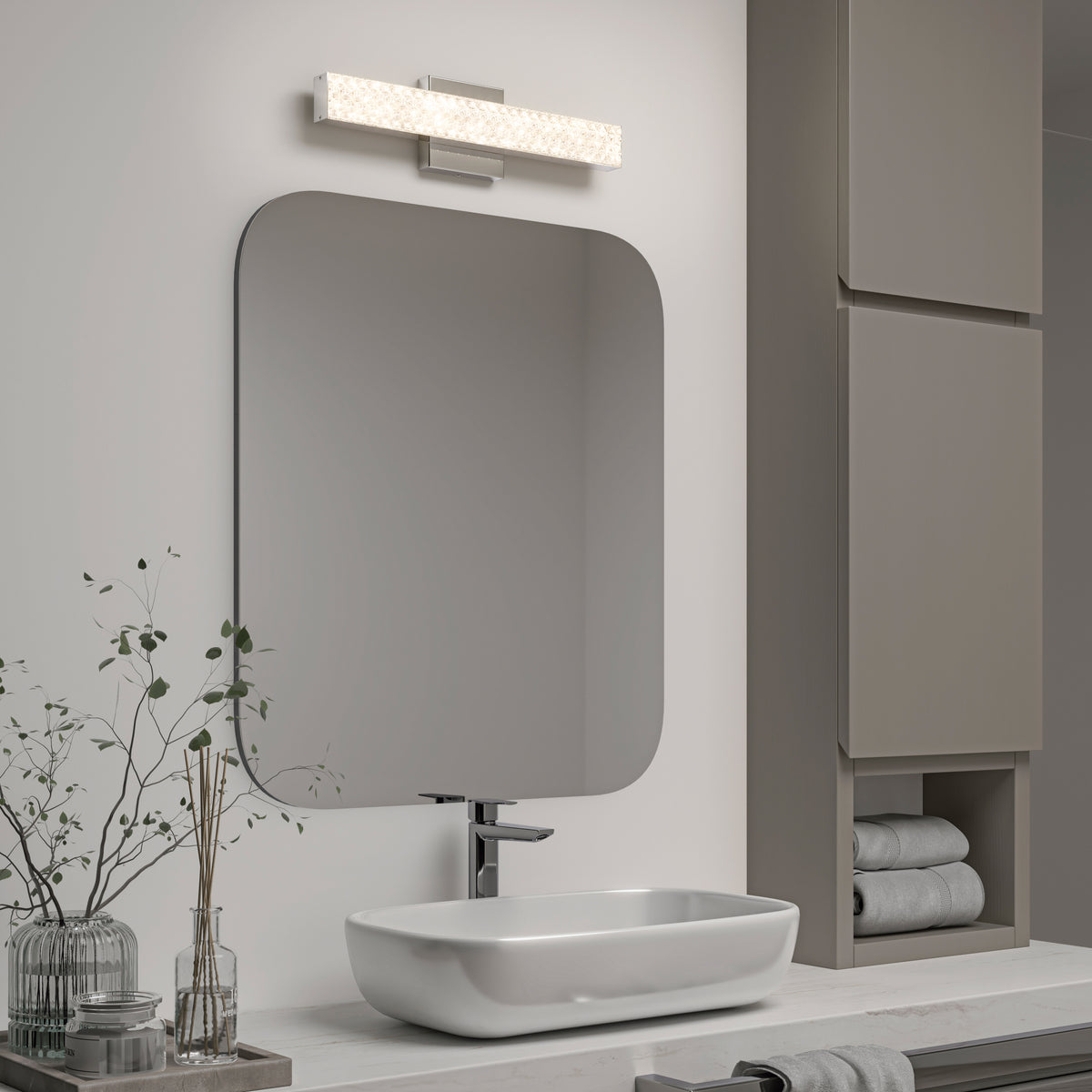 Modern bathroom with a rectangular mirror, vessel sink, Artika Adeline LED vanity light 3 CCT, and shelves with towels and plants.