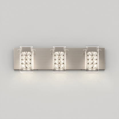 The Artika Crystal Cube LED bathroom vanity light 5 CCT is a modern wall-mounted fixture with three rectangular lights on a brushed metal plate, each encased in clear panels and featuring crystal-style accents for a soft, bright glow.