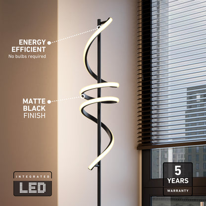 The Artika Coda modern LED floor lamp 5CCT, featuring a matte black arched design and spiral integrated LED, stands by the window. Energy efficient, dimmable, no bulbs needed; includes 5-year warranty.