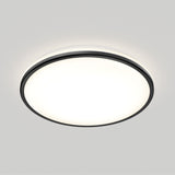 Round, flush-mounted ceiling light fixture with a black rim, glowing brightly against a plain white ceiling.