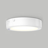 A round, white ceiling-mounted LED light fixture with a motion sensor and two small buttons on its side, shown against a plain gray background.