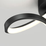 Close-up of a modern, black circular LED light fixture mounted on a white ceiling, with a smooth, minimalist design and a softly glowing light strip.