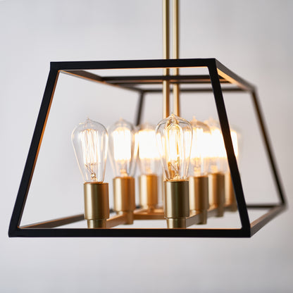 The Artika Carter Long 8-light Chandelier features exposed Edison bulbs in gold sockets, set within a geometric black metal frame and suspended from a gold rod against a plain light background.
