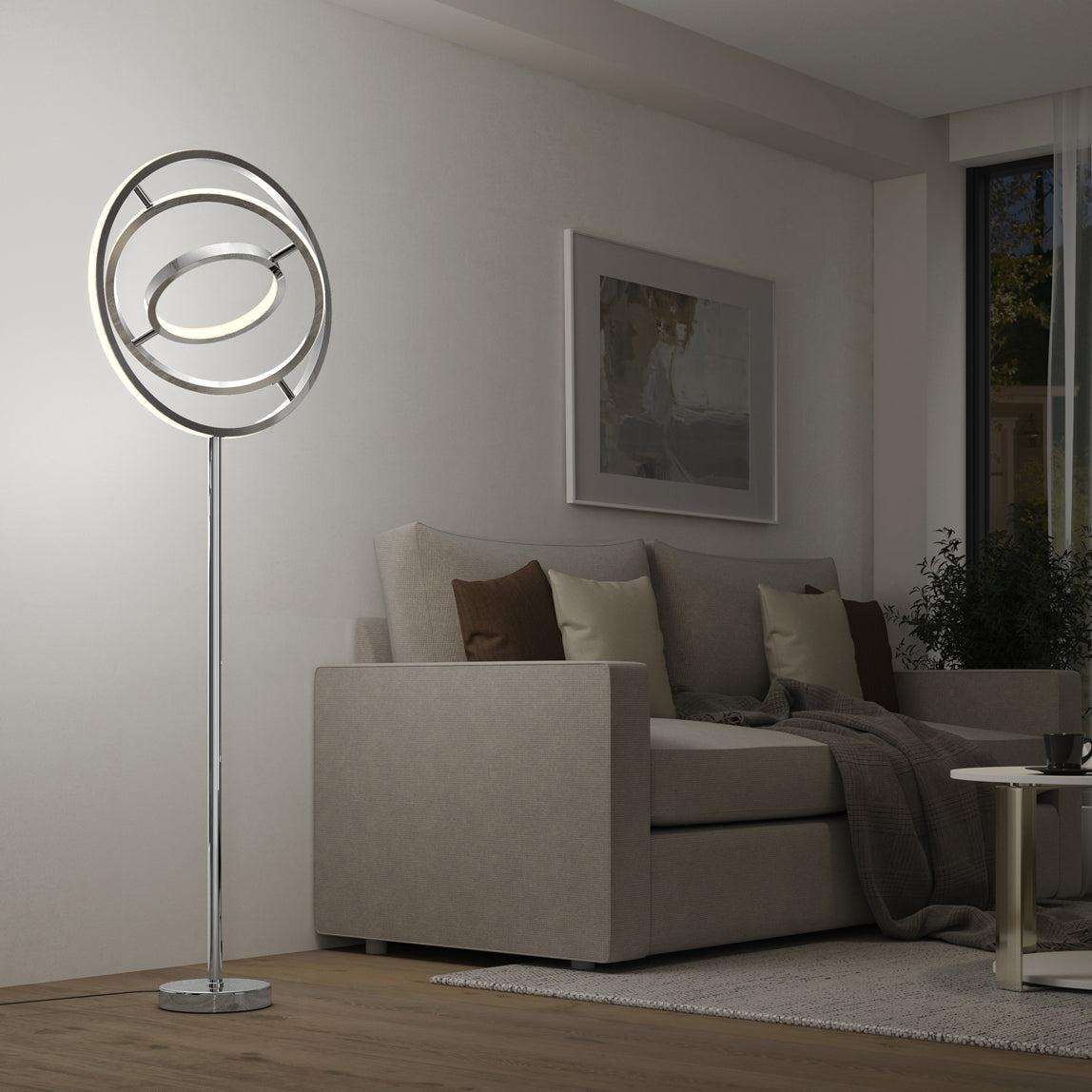 A modern living room featuring a beige sofa, brown and cream cushions, a dark throw, and the Artika Pivot modern LED floor lamp (3 CCT) with circular rings, set beside a coffee table and wall art.