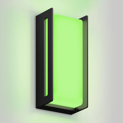 The Artika Ryker smart RGB indoor-outdoor wall light features a modern rectangular black frame and glowing green panel, casting a soft green light on a light gray wall.