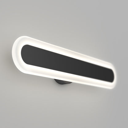 The Artika Pista modern LED bathroom vanity light 5 CCT features an oval design with a black center and glowing white border, mounted on a light gray wall.