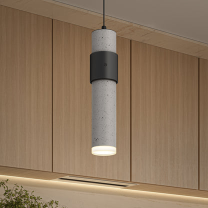The Artika Barden 1-light LED pendant 5 CCT, featuring a sleek concrete and black metal design, hangs from the ceiling in a room with light wood paneling and recessed lighting.