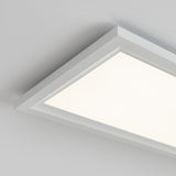 A close-up view of a modern rectangular ceiling light fixture with a white frame, emitting a bright, even light against a plain white ceiling.