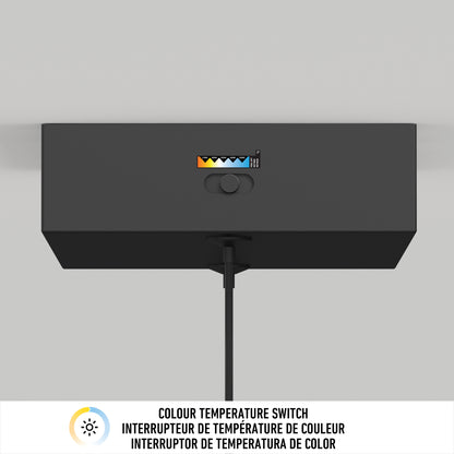 The Artika Coda modern LED pendant light 5 CCT is a black rectangular fixture with a color temperature switch and indicator for various settings, mounted on the wall. A cable hangs below. COLOUR TEMPERATURE SWITCH appears in three languages underneath.
