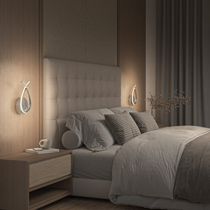 A modern bedroom features a large upholstered headboard, neutral bedding with textured pillows, matching wooden nightstands, and Artika’s Gamma modern LED wall sconces (5 CCT). A small vase with branches adds an extra stylish touch.