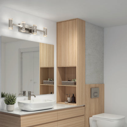 Modern bathroom with light wood cabinetry, a rectangular mirror, and a countertop featuring a white vessel sink. Above the mirror is the Artika Mist modern LED bathroom vanity light 5 CCT. A toilet and neatly arranged toiletries are also visible.